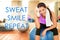 Fitness motivational quote for weight loss motivation. Words SWEAT SMILE REPEAT on gym background with fit Asian woman
