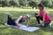 Fitness in the park. The girl on the left has a problem while she does a push-up.