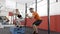 fitness personal trainer follows physical exercises of his young student in a gym