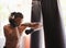 Fitness, punching bag and black man in boxing gym for exercise, challenge or competition training. Power, muscle and