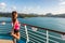 Fitness runner training stretching leg warm-up stretches before running on tracks of cruise ship boat. Woman enjoying view from