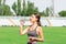 Fitness runner woman drinking water from a sport bottle. energy drink on the training at stadium. Sports and healthy concept.