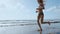 Fitness runner woman running on beach listening to music motivation with phone case sport armband strap. Sporty athlete