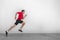 Fitness running man runner profile on wall white background. Male sports athlete sprinting with hiit high intensity