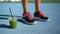Fitness shoes and green smoothie juice cup on running track