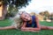 Fitness, sport, exercising, stretching and people concept - smiling blond girl doing splits on the grass