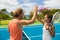 Fitness sport tennis couple giving high five energetic after fun mixed double game. Tennis players friends having fun