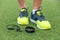 Fitness sport wearable devices man wearing running shoes with wireless earbuds, smartwatch lying on grass floor. Tech