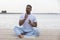 Fitness, sport, yoga and healthy lifestyle concept - close up of people meditating in easy sitting pose on river or lake berth