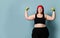 Fitness spring diet weight loss concept. Lucky plus-size girl overweight woman dieting working out with green weights dumbbells