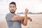 Fitness, stretching and a young man on the beach at the start of his workout for health or wellness. Exercise, thinking