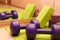 Fitness tools - green and purple cubes and dumbbells on a green mat, sports concept