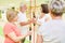 Fitness trainer and seniors group with swinging bar