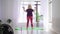 Fitness training - blonde overweight woman doing fitness exercises - standing on yoga mat and training her hands with