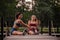 Fitness Training in a Green Park: Athletic Women Stretching and Warming up Outdoors