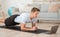 Fitness training, static exercises. Muscular man with laptop makes plank and watches online lesson