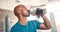 Fitness, water and black man in gym with bottle on workout break to relax at morning challenge routine. Drink, rest and