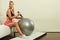 Fitness woman with air pump inflating fit ball