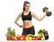 Fitness woman with a broccoli dumbbell behind a table with fruit