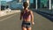 Fitness woman, city runner and training on a road of an urban bridge for a cardio workout from behind. Sport motivation