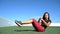 Fitness woman doing ab exercise workout on grass doing Russian Twists