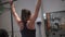 Fitness woman doing barbell push press workout in front of mirror in gym