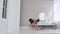 Fitness woman doing burpee workout at home. Medium shot of young woman doing push ups and jump exercise in slow motion