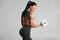 Fitness woman doing exercise for biceps on gray background. Muscular woman workout with dumbbells