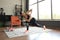 Fitness woman doing forward lunge exercises and watching online tutorials on laptop, training in living room