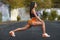 Fitness woman doing lunges exercises for leg muscle workout training, outdoors. Active girl doing front forward one leg step lunge