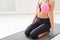 Fitness woman with dumbbells sitting on mat