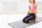 Fitness woman with dumbbells sitting on mat