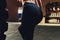 Fitness woman flipping wheel tire in gym. Fit female athlete working out with a huge tire. Back view. Sportswoman doing an