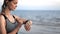 Fitness woman jogging running cardio training use smartwatch sunset summer beach sea waves closeup