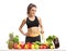 Fitness woman with a measuring tape behind a table with fruit an