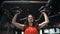 Fitness woman pumping up shoulder muscles in gym