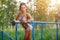 Fitness woman relax after workout exercises on bars outdoor.