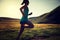 Fitness woman runner running on sunset grassland trail