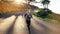 Fitness woman running on an empty road with sun flare in the background. Woman in fitness wear running down a hilly road in the