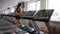 Fitness woman running on treadmill at gym indoors.