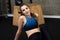 fitness woman sits on the floor at gym with wood jump box in background