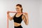Fitness woman with tape measure showing her waist on studio background