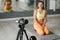 Fitness woman trainer recording video on camera while training at gym indoor. Concept Lifestyle influencer sport and