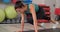 Fitness woman training abdominal muscles in plank pose at gym. Sport woman standing in plank training abdominal muscles