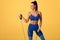 Fitness woman working out with resistance band on gray background. Athletic girl exercises with expander