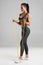 Fitness woman workout with resistance band isolated on gray background. Athletic girl doing exercise for biceps