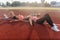 Fitness women relaxing after training. Tired athletes lying workout together in circle in stadium