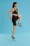 Fitness workout. Woman exercising, jumping on blue background