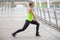 fitness young woman stretching leg on a rail bridge workout exercising on street in urban city . runner sport girl warm up .