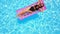 Fitted pretty girl in bikini chilling on inflatable pink mattress in swimming pool. Shaped woman in swimsuit tanning